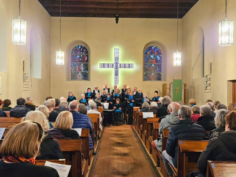 Blick auf den Chor und Besucher*innen des Konzerts in einer Kirche