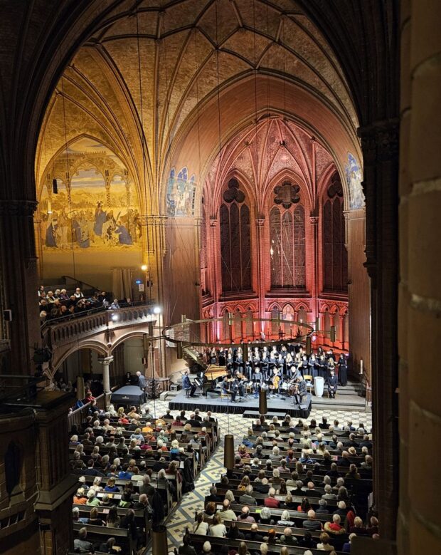 Blick von der Empore in der Kirche auf Publikum und Ensemble mit Chor